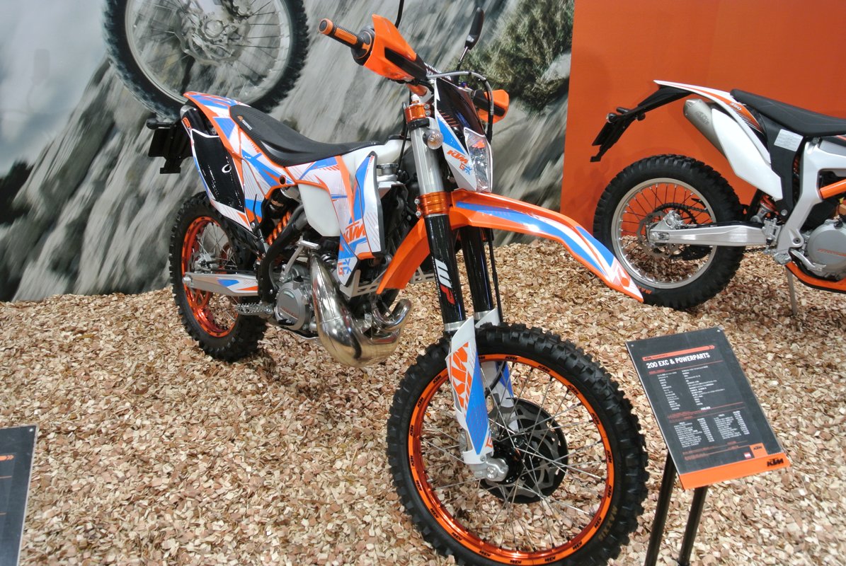 A KTM EXC enduro displayed with aftermarket PowerParts at a motorcycle show