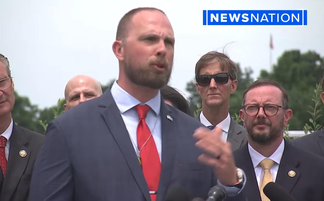 David Grusch speaking at his June 2026 public statement on Capitol Hill, flanked by officials