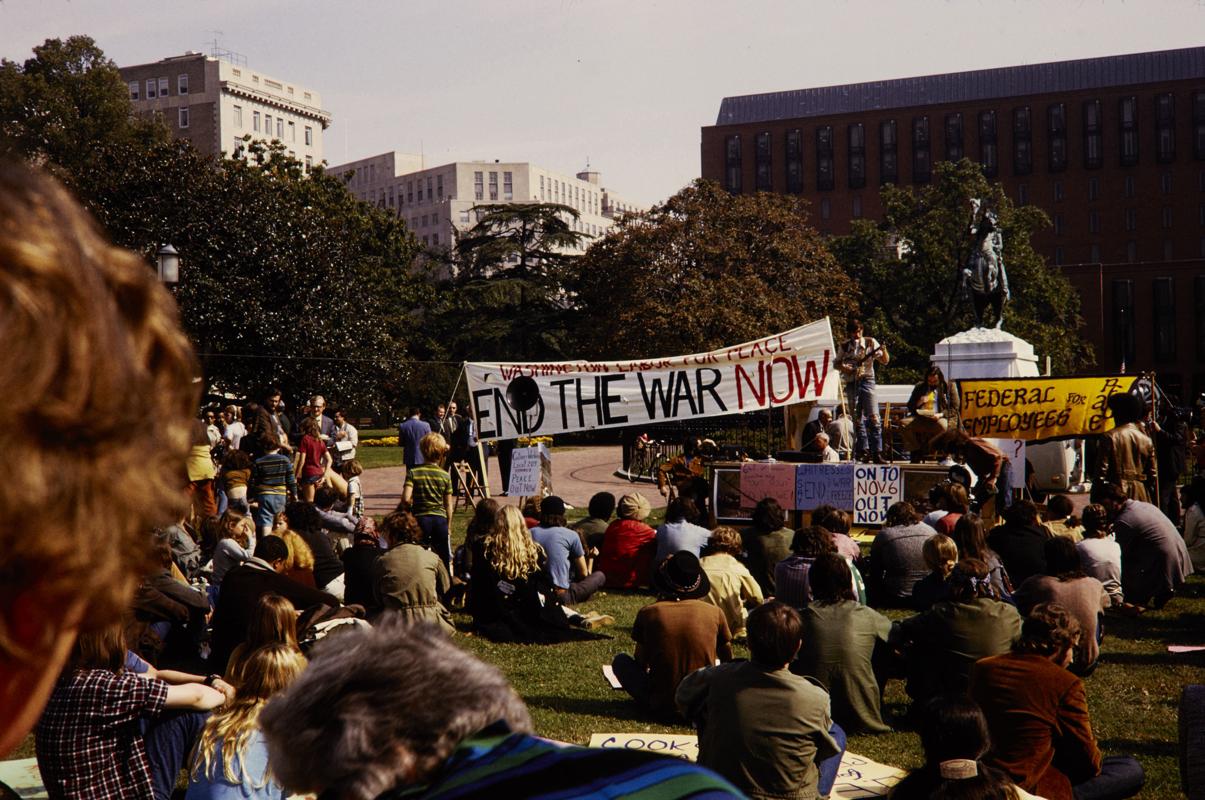 Multitud en una manifestación contra la guerra en Washington DC con una pancarta que pide el fin de la guerra