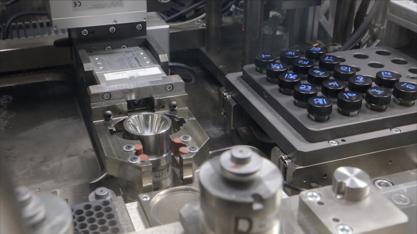 Trabajador manipulando material radiactivo a través de los guantes sellados de una caja de guantes